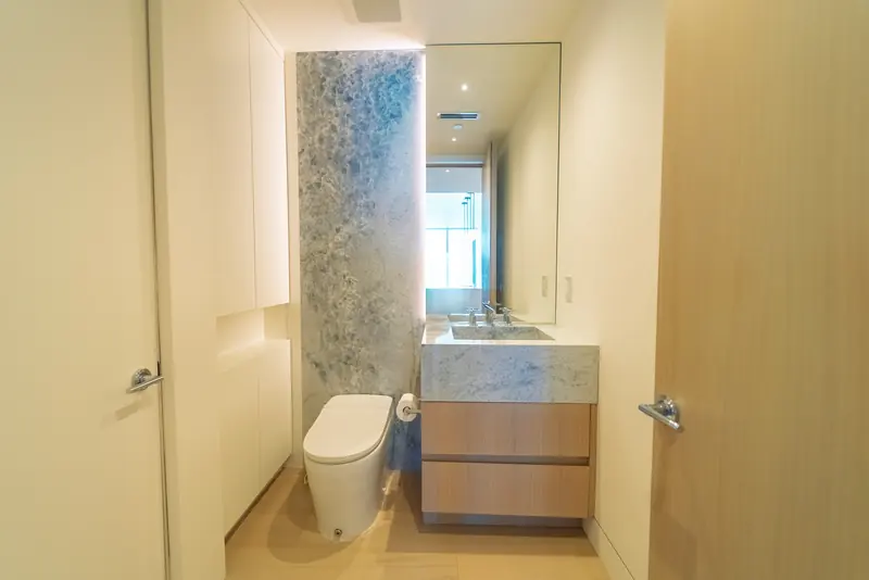 Baño de visitas con pared decorativa de piedra en Continuum South Tower, Miami Beach