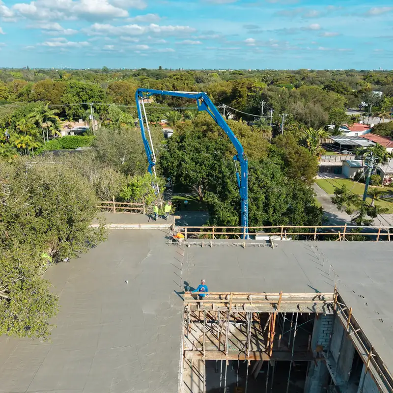 Pluma de la bomba de concreto sobre el vaciado de la losa del segundo piso en Kaēlo Residence, Miami Shores